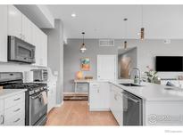 Modern kitchen features stainless appliances, white cabinets and hardwood floors at 1820 Mary Ln # 16, Boulder, CO 80304