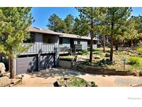 Inviting two-car garage and a charming porch welcome you to this attractive gray mountain home at 191 Alder Ln, Boulder, CO 80304