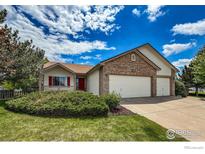 Charming home featuring a brick facade, three-car garage, and well-manicured lawn at 2344 Flagstaff Dr, Longmont, CO 80504