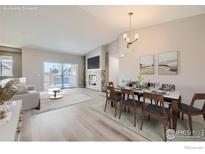 Bright, open living room features a stone fireplace, balcony access, and neutral décor at 2435 Calais Dr # B, Longmont, CO 80504