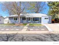 Charming single-story home featuring mature trees, a well-kept lawn, and a welcoming front porch at 2561 S Carey Way, Denver, CO 80222