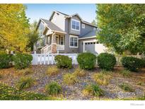 Charming two-story home with a landscaped front yard and white picket fence, creating a welcoming curb appeal at 2758 Meadow Mountain Trl, Lafayette, CO 80026