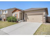 Tan home with a 2 car garage, landscaped yard, and concrete driveway at 7225 Shavano Ave, Frederick, CO 80504