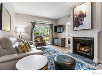 Cozy living room featuring a fireplace, plush seating, and sliding door to a balcony at 7452 Singing Hills Dr, Boulder, CO 80301