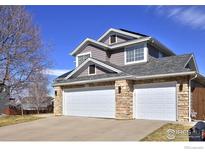 Charming home featuring a two-car garage with stone accents and a well-maintained front yard at 9436 Cody Dr, Broomfield, CO 80021