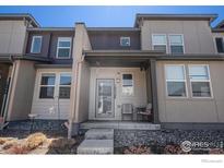 Charming townhome with a welcoming front porch and neutral-toned facade at 16058 E Elk Dr, Denver, CO 80239