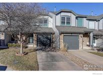 Charming townhome featuring a gray exterior, attached garage, and well-maintained front yard at 1978 E 102Nd Cir, Thornton, CO 80229