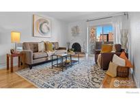 Inviting living room featuring a decorative fireplace, large rug, balcony access, and comfortable seating arrangement at 252 N Pennsylvania St # 305, Denver, CO 80203
