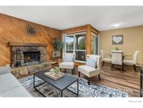 Cozy living room with stone fireplace and wood paneled accent wall at 3030 Oneal Pkwy # 18, Boulder, CO 80301