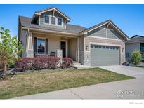 Charming home with a covered front porch, well-maintained lawn, and a two-car garage at 3295 Heron Lakes Pkwy, Berthoud, CO 80513