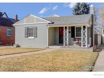 Charming grey brick home featuring a cozy front porch and manicured lawn at 3441 W 45Th Ave, Denver, CO 80211