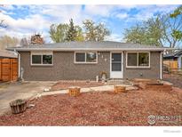 Charming brick home featuring a well-maintained front yard with mature trees and landscaping at 417 E 4Th Ave, Longmont, CO 80504