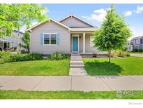 Charming single-story home featuring a well-maintained lawn, concrete stairs and a bright blue front door and window shutters at 4672 Clear Creek Dr, Longmont, CO 80504