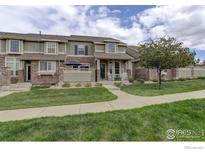 Inviting townhome with lush green lawn and charming stone accents at 4784 Raven Run, Broomfield, CO 80023