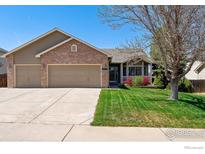 Charming home with a well-maintained lawn and a two-car garage, blending brick and siding for a classic look at 4835 Egret Dr, Frederick, CO 80504