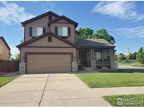 Two-story home featuring a front porch with stone accents and well-maintained lawn at 548 Mathews Cir, Erie, CO 80516