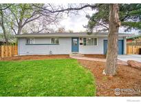 Charming home featuring a well-manicured lawn, blue accents, and mature trees in a tranquil, inviting neighborhood at 810 34Th St, Boulder, CO 80303