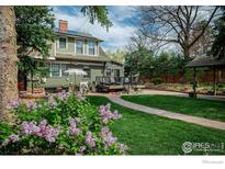 Beautifully landscaped backyard with a patio, a brick walkway, and lush green grass at 845 14Th St, Boulder, CO 80302