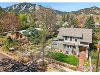 Charming two-story home with landscaped yard and brick walkway situated against a mountain backdrop at 845 14Th St, Boulder, CO 80302
