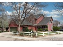 Charming two-story home with a well-manicured lawn and a white picket fence at 914 Snowberry St, Longmont, CO 80503