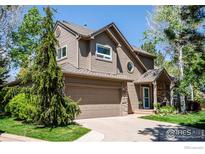 Charming two-story home showcasing a well-maintained front yard, attached garage, and inviting exterior design at 100 Springs Cv, Louisville, CO 80027