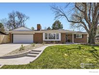 Charming brick home featuring a manicured lawn, attached garage and inviting curb appeal on a sunny day at 10340 W 34Th Ave, Wheat Ridge, CO 80033