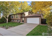 Charming two-story home featuring an attached two-car garage and a well-maintained front yard with mature trees at 106 Starline Ave, Lafayette, CO 80026