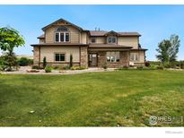 Charming two-story home with brick accents and a lush green lawn at 1105 Shelby Dr, Berthoud, CO 80513