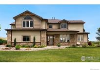 Charming two-story home featuring a landscaped yard, brick accents, and beautiful architectural details at 1105 Shelby Dr, Berthoud, CO 80513