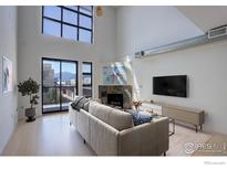 Bright living room with a fireplace, large windows, and a view of the mountains at 1200 Yarmouth Ave # 238, Boulder, CO 80304
