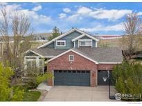 Two-story brick and siding home with a two-car garage and landscaped front yard at 1271 Hickory Dr, Erie, CO 80516