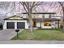Inviting two-story home featuring a spacious front porch, painted brick, and manicured lawn at 1424 Kennedy Ct, Boulder, CO 80303