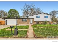 Charming split-level home with brick and siding, a well-maintained lawn, and inviting curb appeal at 1430 Lashley St, Longmont, CO 80504