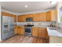 Kitchen features stainless steel appliances, wood cabinets, and tile countertops at 1842 Reliance Cir, Superior, CO 80027