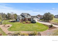 Charming two-story home with brick accents, a well-manicured lawn, and mature landscaping at 18553 Wagon Trl, Mead, CO 80542