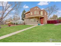 Modern two-story home with red front door, neutral siding and manicured lawn at 2624 S Race St, Denver, CO 80210