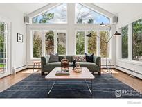 Bright living room with large windows, hardwood floors, stylish furniture, and natural light at 3890 Norwood Ct, Boulder, CO 80304