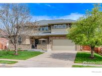 Inviting two-story home showcasing a stone facade, well-manicured lawn, and a two-car garage at 4203 Rabbit Mountain Rd, Broomfield, CO 80020