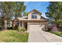 Charming two-story home with stone accents, a well-manicured lawn, and mature trees at 5587 Glendale Gulch Cir, Boulder, CO 80301