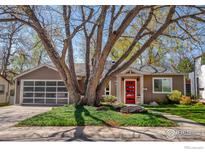 Charming home featuring an attached garage, well-manicured front yard, and a striking red front door at 560 Iris Ave, Boulder, CO 80304