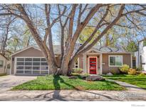 Charming single-story home with a beautifully landscaped front yard and a modern red front door at 560 Iris Ave, Boulder, CO 80304