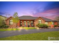 Charming brick and siding home with a well-manicured lawn and a circular driveway at 6319 Sedona Hills Dr, Berthoud, CO 80513