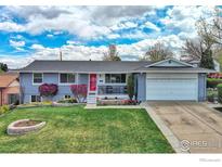 Charming single-story home features a well-manicured lawn, lovely landscaping, and a bright red front door at 8200 Delaware St, Denver, CO 80221