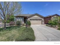 Charming single-story home with a well-maintained lawn and lush landscaping at 8255 E 150Th Pl, Thornton, CO 80602