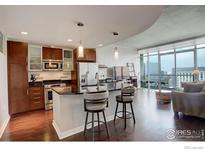 Modern kitchen with stainless steel appliances, granite countertops, and bar seating opens to great room at 891 14Th St # 3815, Denver, CO 80202