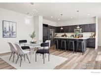 Dining area with modern furnishings and a view of the gourmet kitchen at 10022 Reunion Pkwy, Commerce City, CO 80022