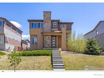 Beautiful two-story home featuring stone accents and landscaped front yard at 10022 Reunion Pkwy, Commerce City, CO 80022