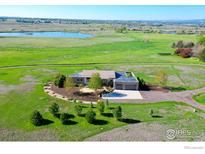 Stunning aerial view of a modern home with a circular driveway and scenic natural surroundings at 11251 Lookout Dr, Longmont, CO 80504