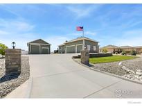 Inviting home with a spacious driveway, standalone garage, and well-manicured lawn at 11500 E 162Nd Dr, Brighton, CO 80602