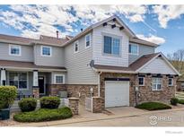 Charming townhouse with stone accents, attached garage, and well-maintained landscaping at 14000 Winding River Ct # T3, Broomfield, CO 80023